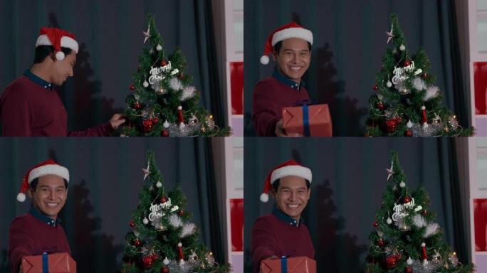 戴着红帽子的亚洲年轻人赠送礼盒并在客厅说 “新年快乐” 和 “圣诞节”