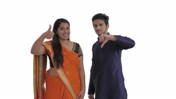 印度夫妇表达相反的情感。微笑的女人竖起大拇指。沮丧的人竖起大拇指。孤立在白色背景上