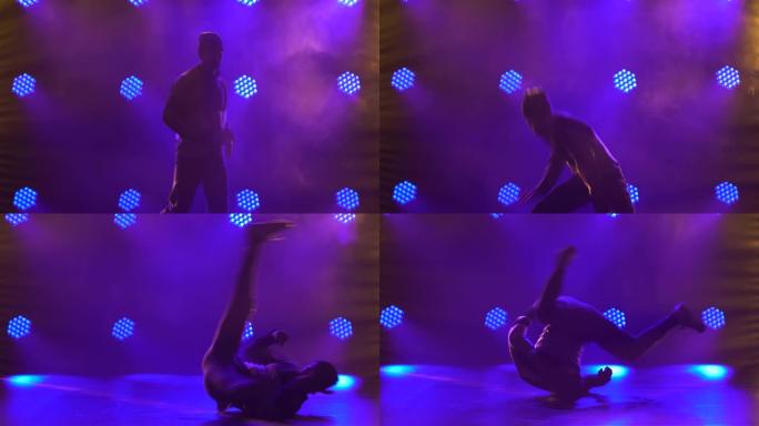 一个男舞者的剪影在工作室里跳霹雳舞、嘻哈、街舞，与世隔绝。年轻人在带有紫色背光的黑暗工作室中表演霹雳