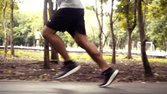 特写腿地道的亚洲人在公园里跑步。