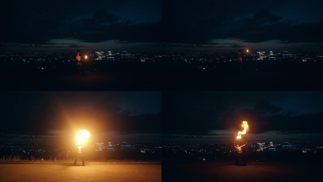 年轻的金发男性用火耍花招，半夜用城市天际线在背景中呼吸火