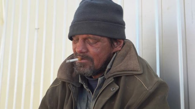 无家可归的人在户外抽烟。乞丐坐在街上