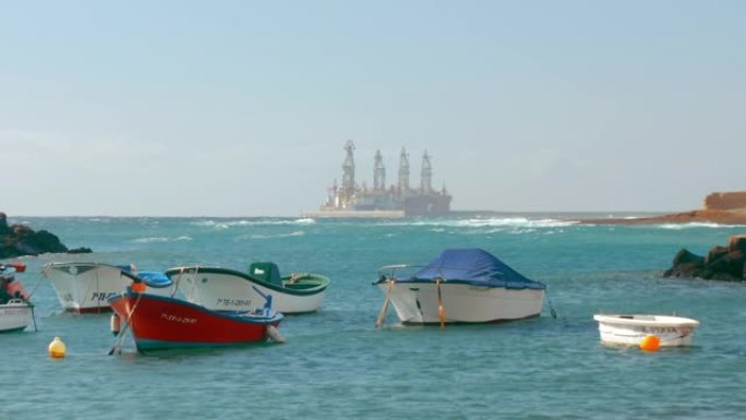 日出时的玛丽娜。背景中的石油生产钻机。大西洋上的海湾里有很多船和船。环境保护与碳排放的概念