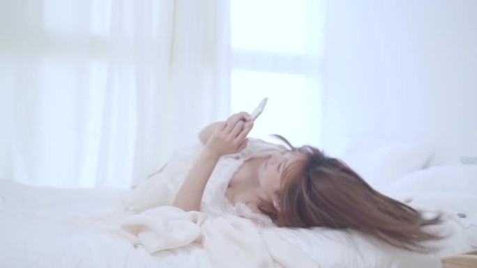 家里休闲的女人在床上玩手机