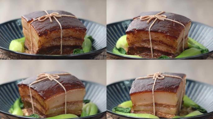 东坡肉 (东坡猪肉) 在美丽的蓝色盘子里搭配绿色的清江蔬菜，传统的节日食品为中国新年美食餐，特写，旋