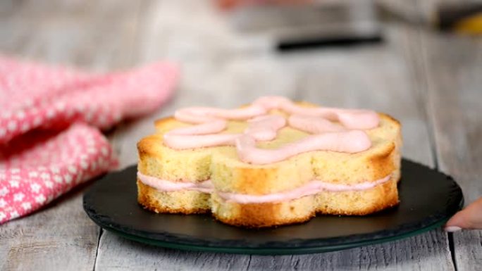 糕点师正在制作花朵形状的粉红色蛋糕。系列。