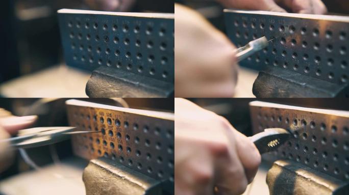 珠宝商拉金杆穿过工具模具特写的孔