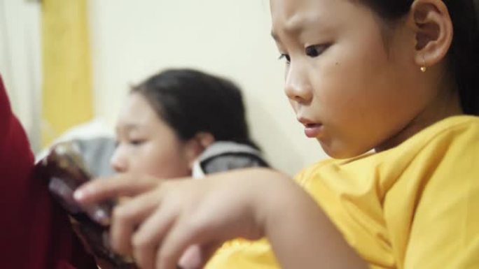 快乐的亚洲女孩在家里一起在数字桌子上玩网络游戏。