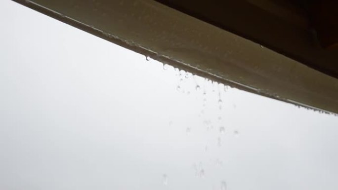雨滴从屋顶排水沟滴入水桶