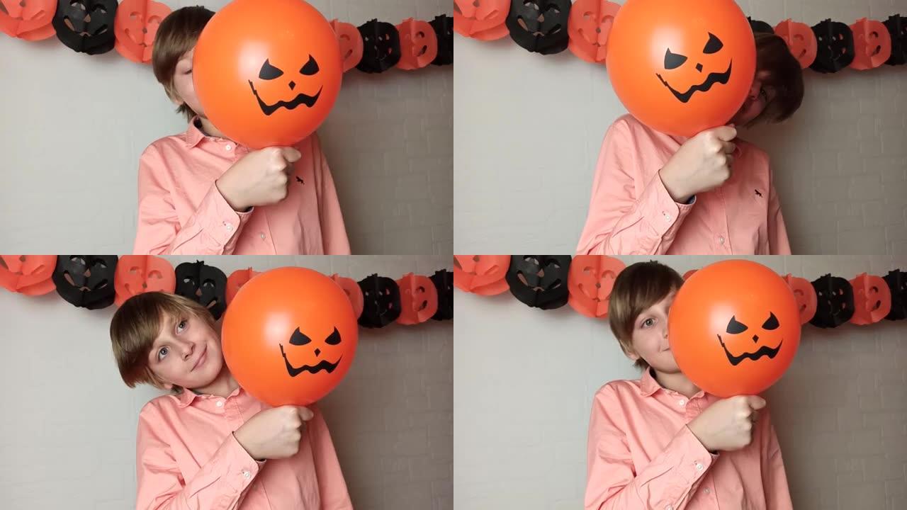 一个男孩把脸藏在橙色南瓜气球后面，家里有Jack'O灯笼的脸，玩耍，再次露面