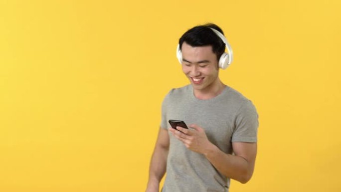 戴着耳机听音乐的微笑亚洲男子