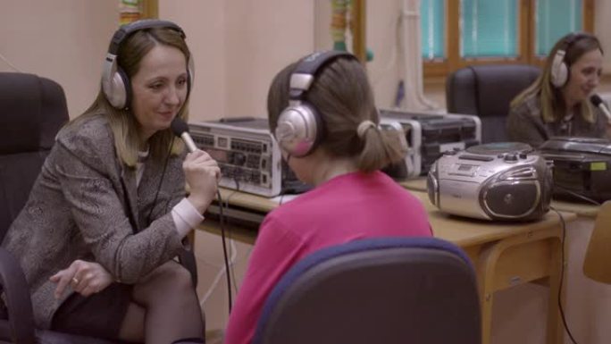 语音治疗师在音频实验室与残疾女孩一起工作