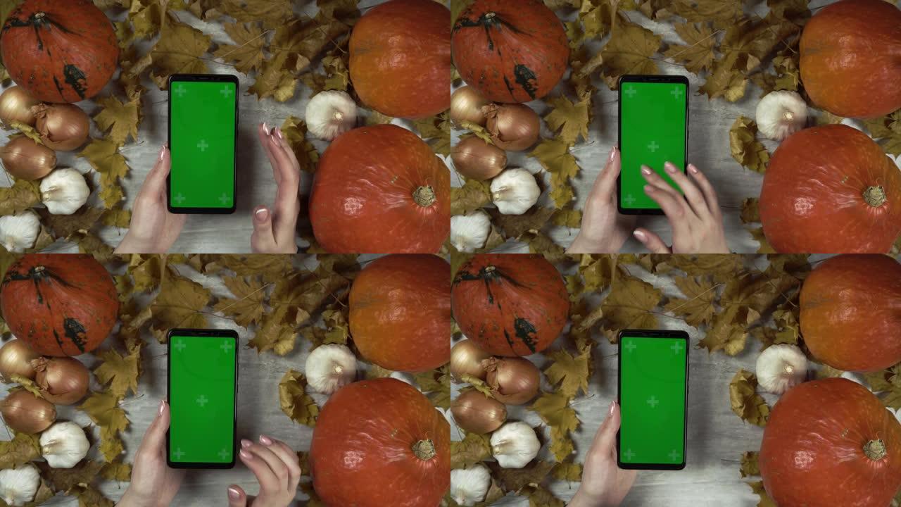 女人用绿屏移动手机，用右手轻敲和滑动屏幕