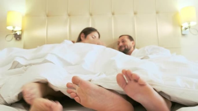 这对夫妇的赤脚躺在床上。