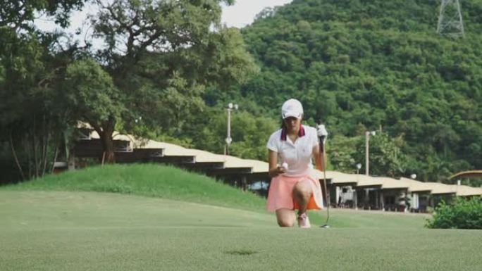 女高尔夫球手将球放在绿色上的镜头，视频慢动作