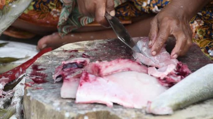 当地妇女在人行道上切割鲜鱼，街头食品