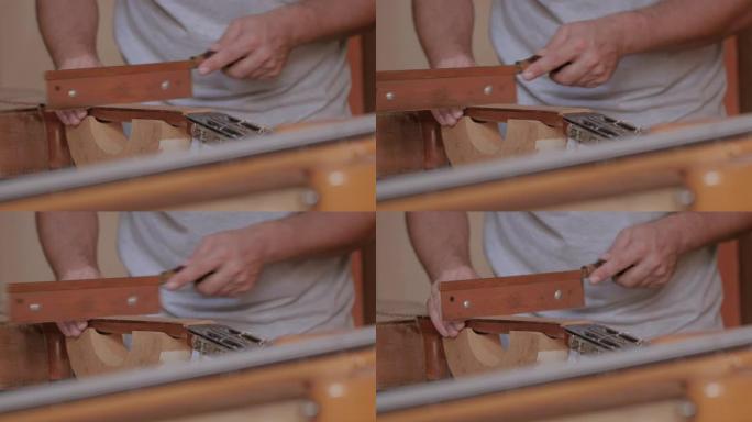 年轻的乐器制造商在他的工作室里锯吉他的细节