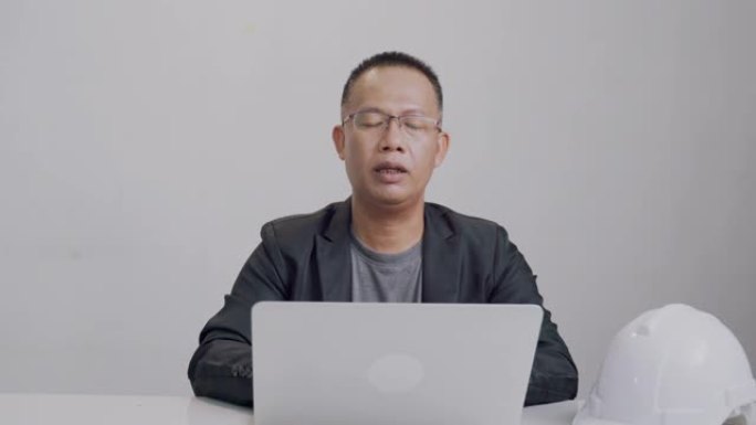 40-50岁的亚洲男人，看着平板电脑阅读在线教育或会议的实践测试。穿着休闲装的亚洲男性正在通过视频会