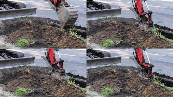 城市市政拖拉机用钢包在土方工程上挖下水道。