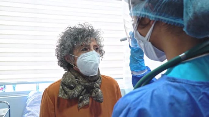 女医生检查一名老年患者因新型冠状病毒肺炎大流行而采取的所有保护措施