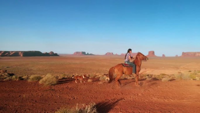 黄昏时，年轻的美国原住民纳瓦霍族少女在亚利桑那州北部沙漠的纪念碑谷部落公园骑马