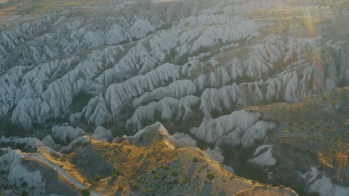 日落时卡帕多西亚地区令人印象深刻的全景，砂岩、峡谷、葡萄园和徒步旅行小径的圆锥形美景。这是著名的旅游