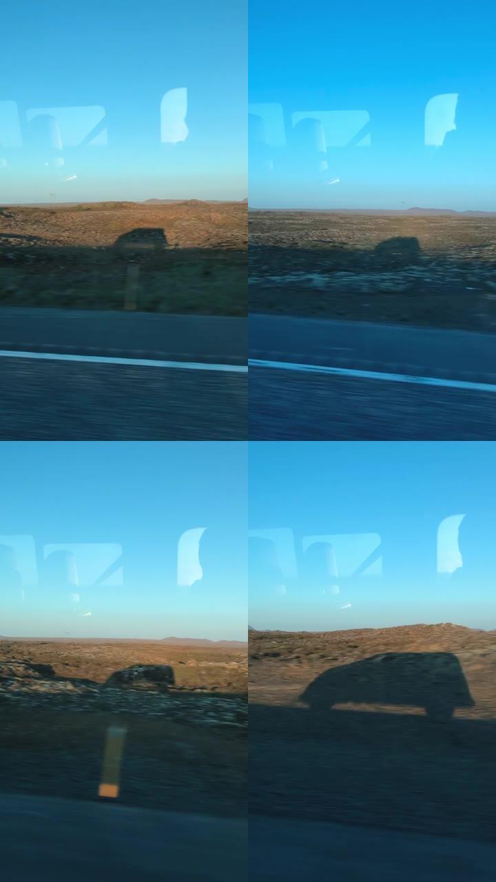 一辆面包车在冰岛火山景观上行驶的阴影