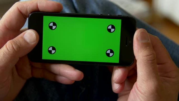 手握智能手机。绿屏色度键。特写。跟踪运动。