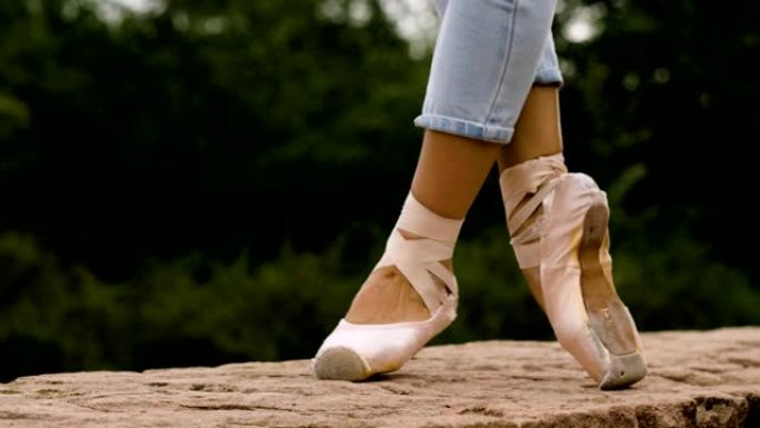 现代芭蕾舞演员的脚在街上的脚尖上跳舞。4K