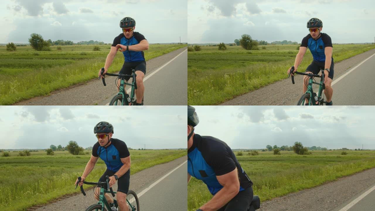 骑自行车的人正在查看健身追踪器上的训练数据。他开始提高骑行速度。骑自行车训练。背景中有一块绿色的田野