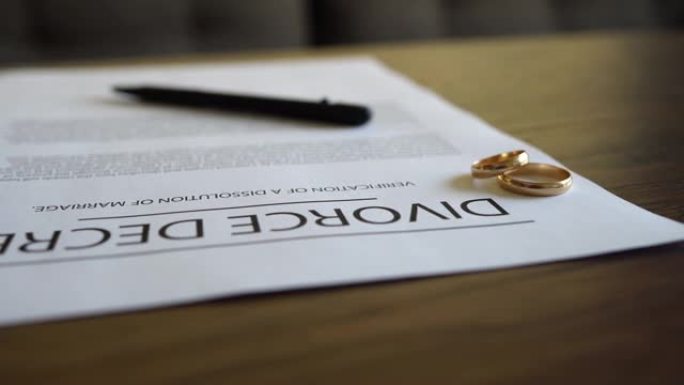 桌子上有结婚戒指的离婚法令协议。