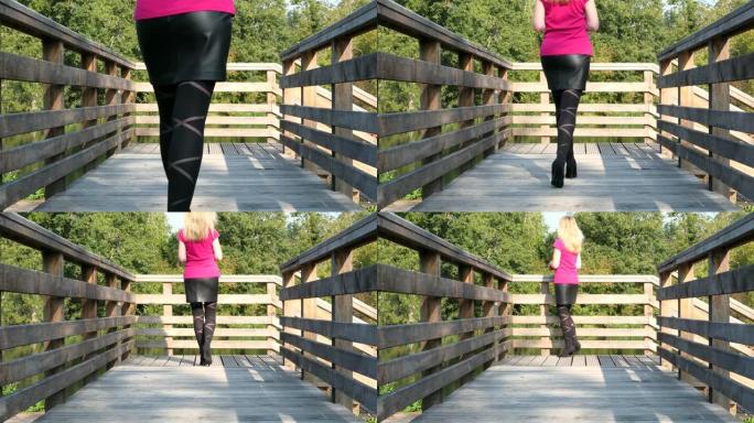 穿高跟鞋走在木桥上的女人。