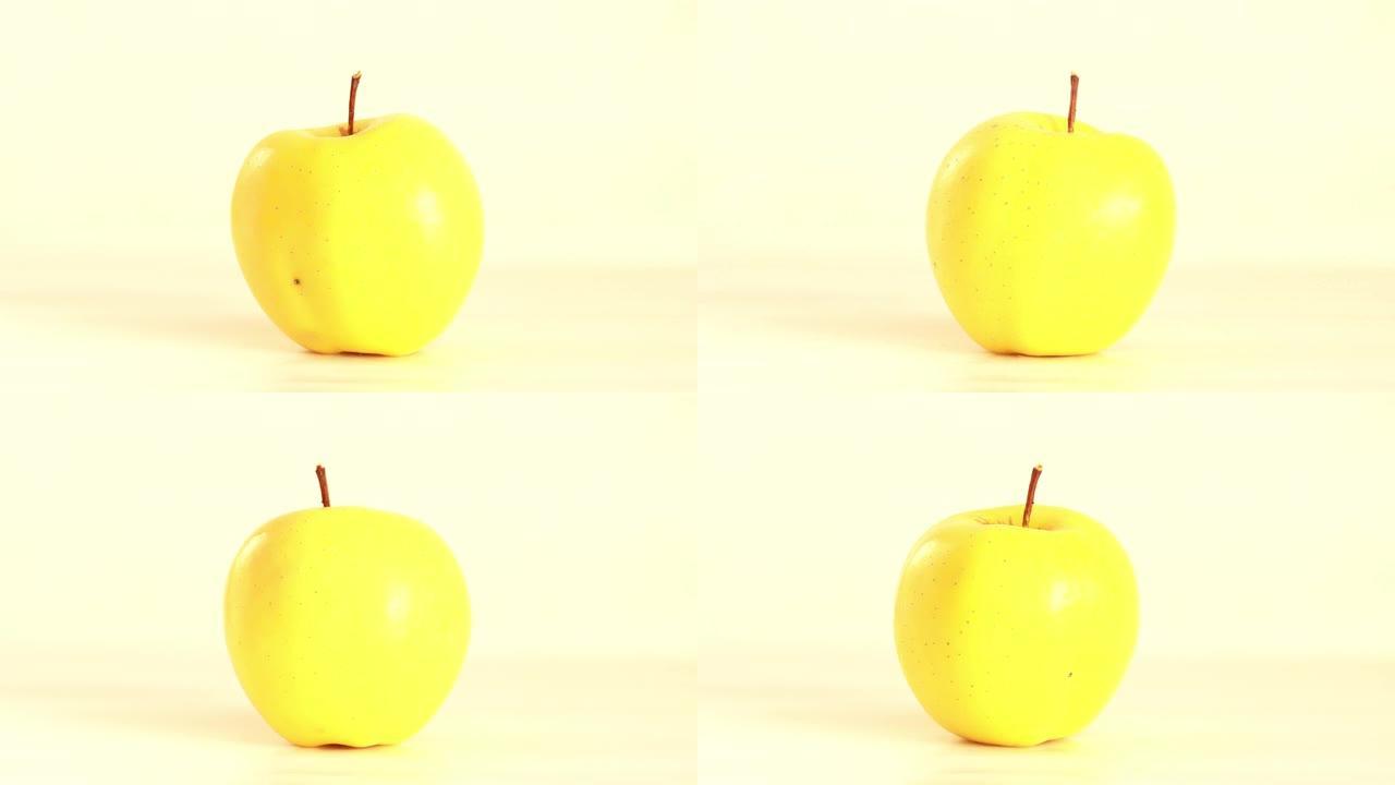 黄色苹果在白色背景上旋转 -- 停止动作镜头