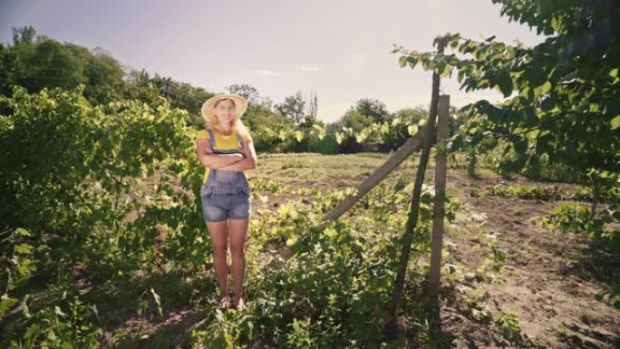 年轻的女农夫站在种植园上。果园里一个女园丁的肖像