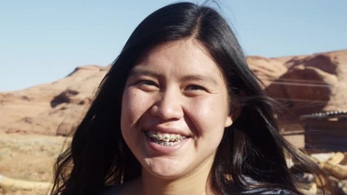 纪念碑谷印第安人保留地亚利桑那州北部沙漠中一位美丽的纳瓦霍印第安人印第安女孩的户外肖像