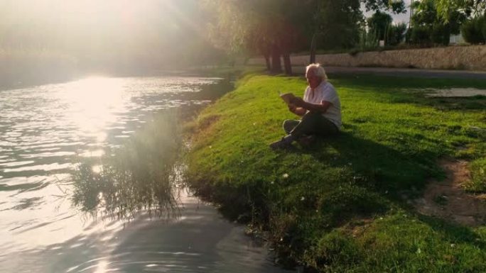 退休绅士在河边的田野里读书