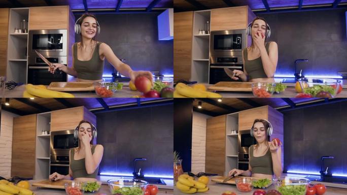 美丽微笑的快乐年轻女子的特写镜头，她在厨房里戴着耳机听音乐时吃苹果
