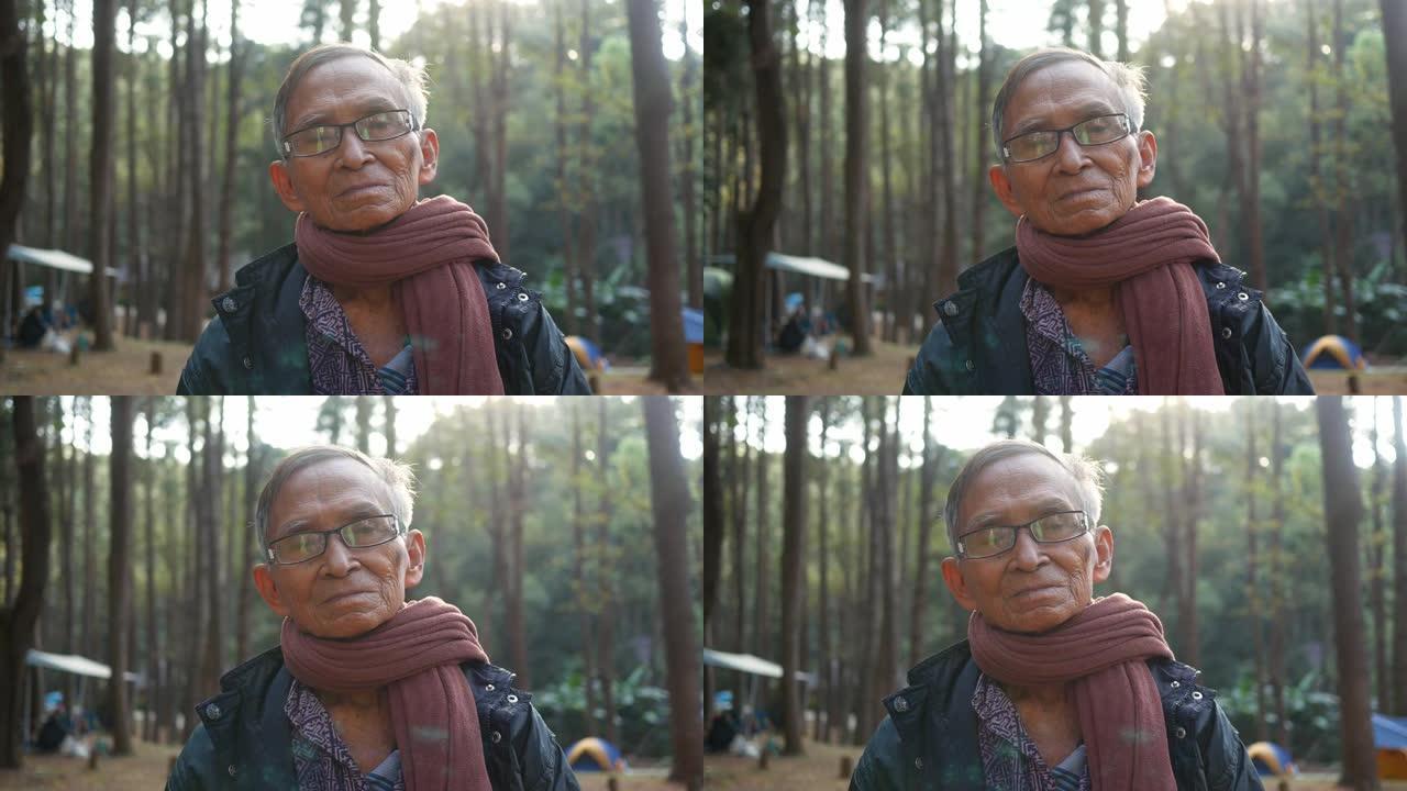 快乐的亚洲祖父在寒冷的季节与孙子在松树林中露营。
