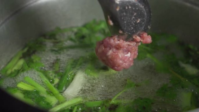 厨师用开水将猪肉末倒在锅上。慢动作