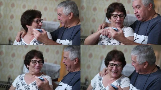 快乐的老年夫妇对手机上的好消息做出反应。高级丈夫与妻子共享智能手机屏幕