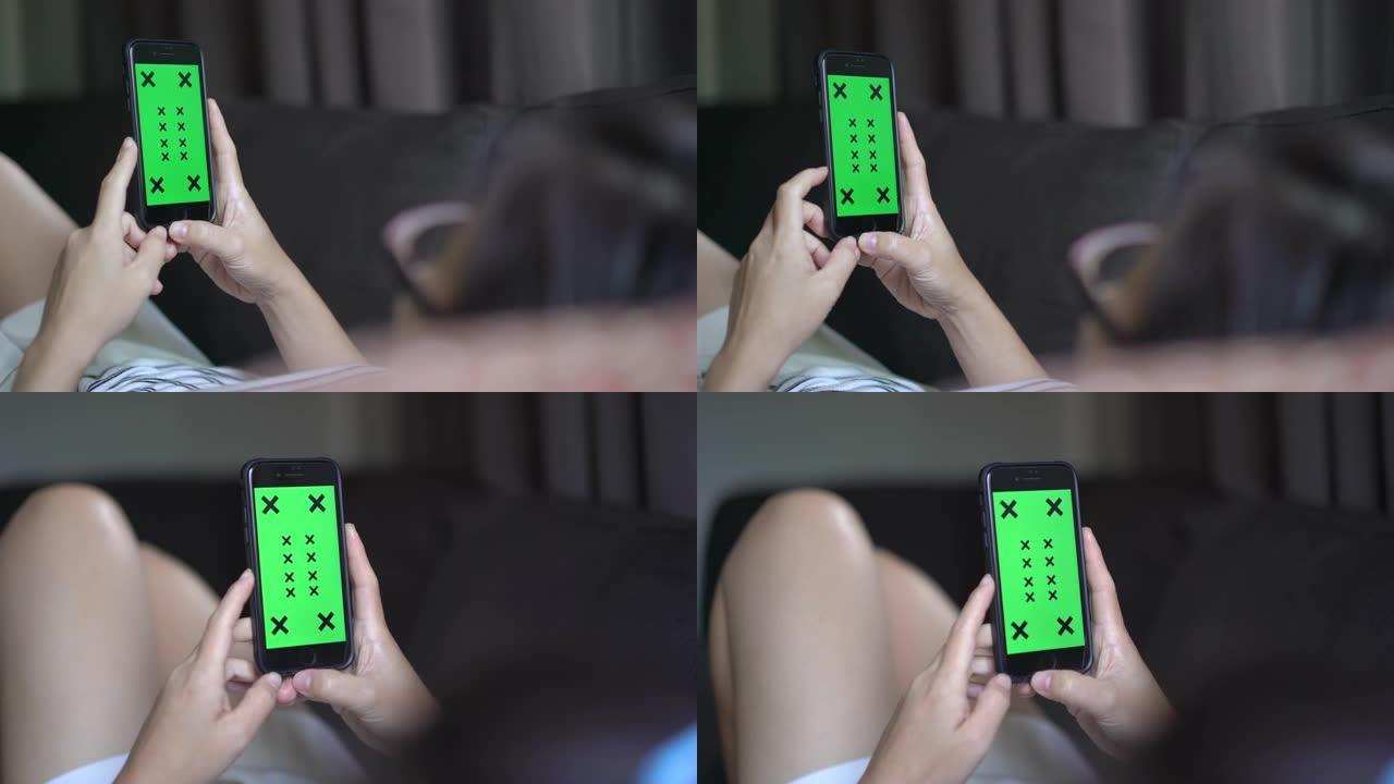 在客厅使用和看着智能手机绿屏的女人的手的2张照片