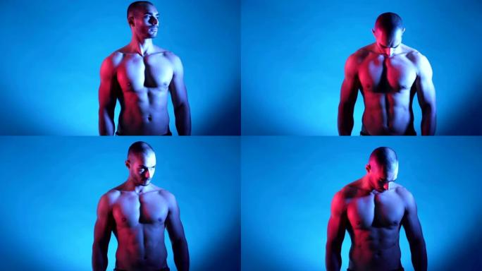 肌肉发达的健身男子躯干，六包摆姿势，在蓝色背景的工作室拍照