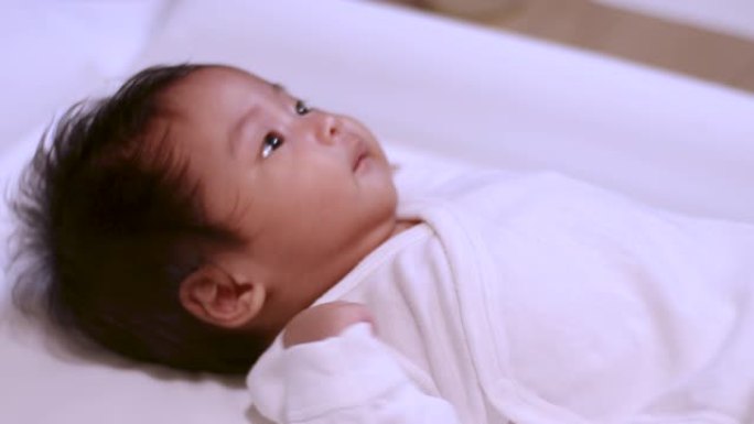 4k亚洲婴儿女婴在家洗完澡后躺在相机上，温暖快乐，舒适，长袍，婴儿躺在桌子上，白天，清洁卫生，抗菌，