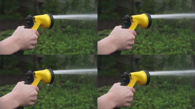 用喷枪洒水。给花园浇水。