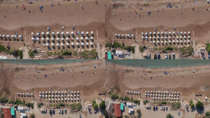 珊瑚湾海滩鸟瞰图，带伞和人。著名的塞浦路斯美丽的海岸线，蔚蓝的地中海海水和沙滩，无人机镜头