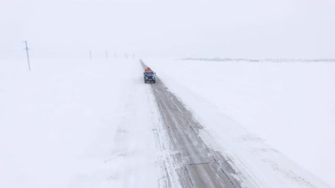 油罐车在积雪的田野中沿着空旷的道路行驶