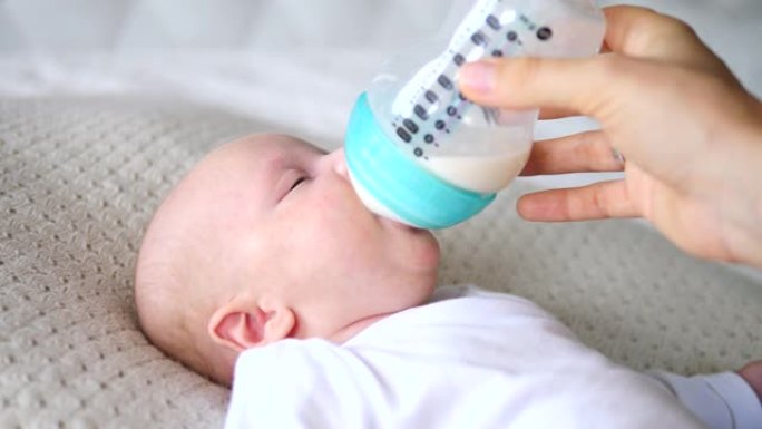 喂养婴儿。婴儿吃奶瓶里的牛奶。母亲喂养她刚出生的婴儿。