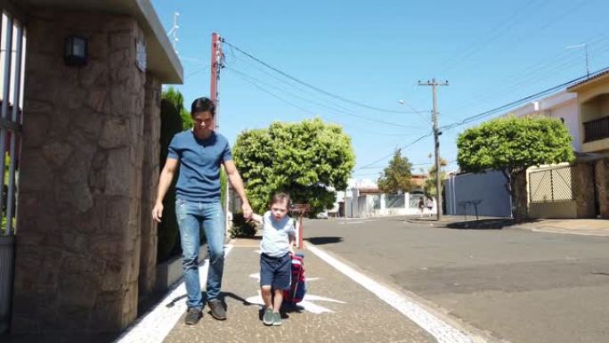 父亲和儿子一起散步回到学校。向下。