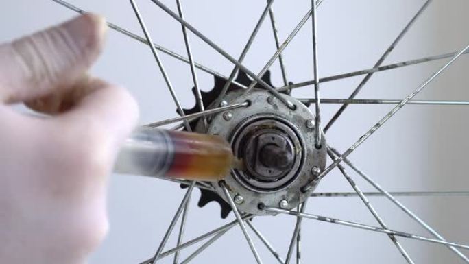 自行车车轮后套筒的组装。视频特写在后轮毂上涂抹润滑脂。
