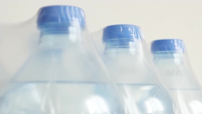 包装瓶装水特写倾斜镜头-透明液体缓慢倾斜的宠物容器